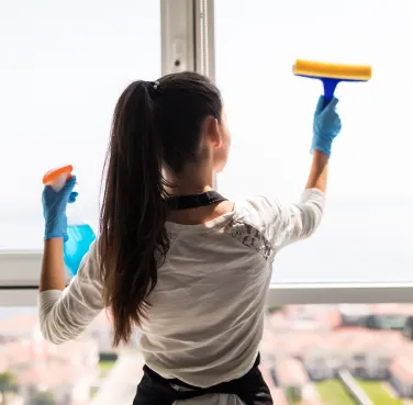 Nett Services, nettoyage de vitre à Quimper Femme nettoyant une vitre